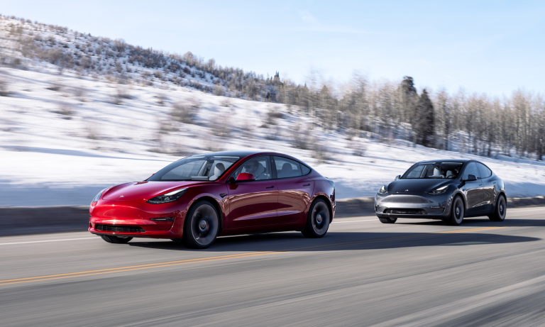 two-teslas-in-a-line-driving-on-road-1.png
